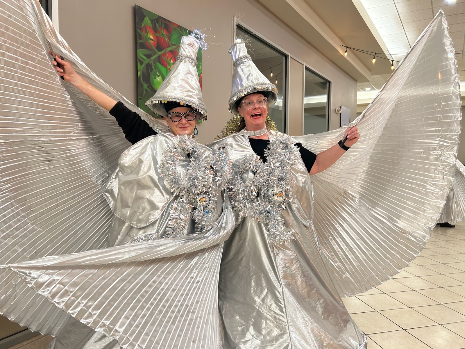 The Silver Belles in magnificent silver hoop skirts, conical hats, and huge pleated wings